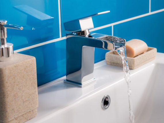 The new and modern steel faucet with the ceramic sink in the bathroom
